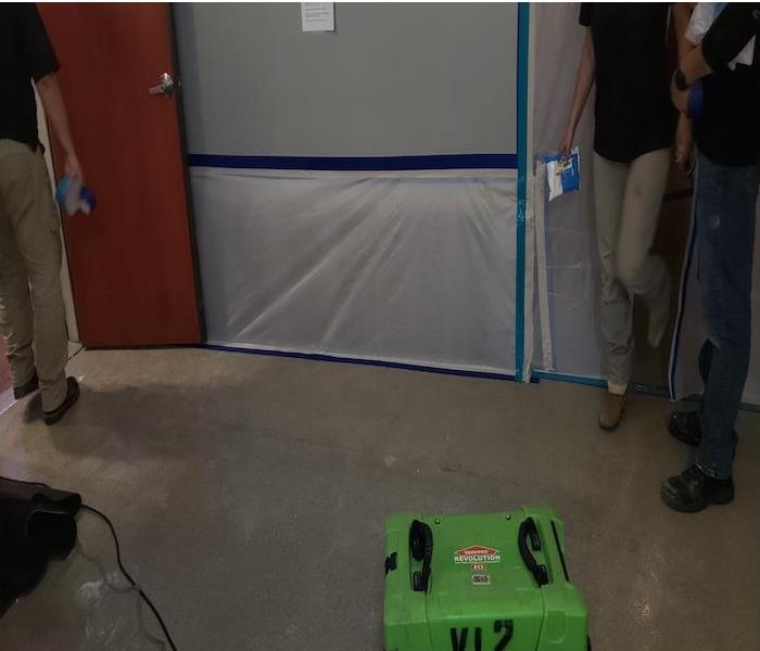 plastic containment on wall with green equipment 