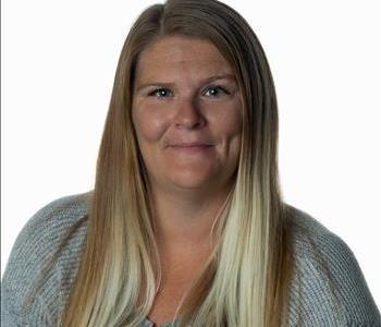 Blonde woman in SERVPRO uniform posing for a picture on a white background