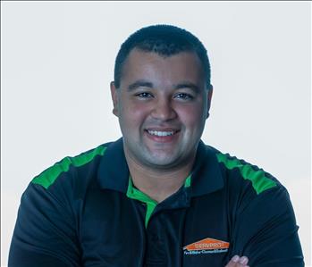 Man in SERVPRO uniform posing for a picture on a white background