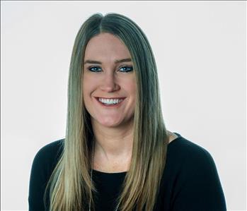 Woman in SERVPRO uniform posing for a picture on a white background