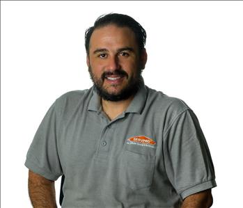 Man in SERVPRO uniform posing for a picture on a white background