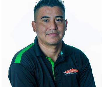 Man in SERVPRO uniform posing for a picture on a white background