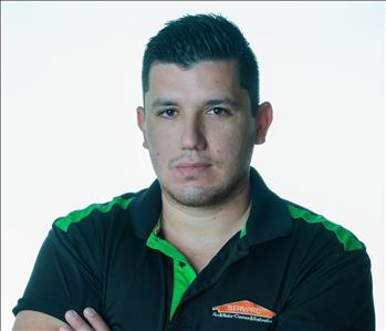 Man in SERVPRO uniform posing for a picture on a white background