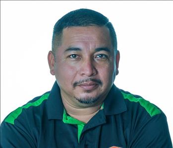 Man in SERVPRO uniform posing for a picture on a white background