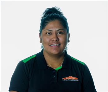 Brunette woman in SERVPRO uniform posing for a picture on a white background