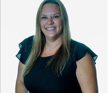 Blonde woman in SERVPRO uniform posing for a picture on a white background