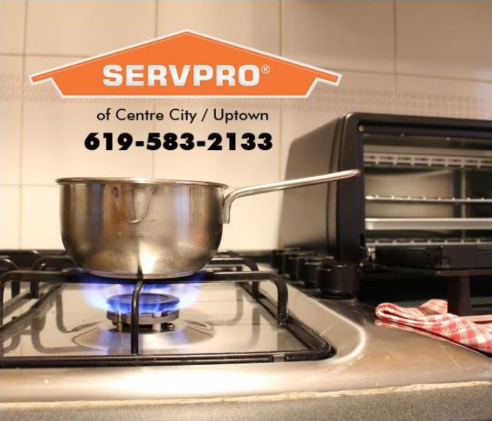 A pot is shown sitting on a lit gas burner in a kitchen, unattended.